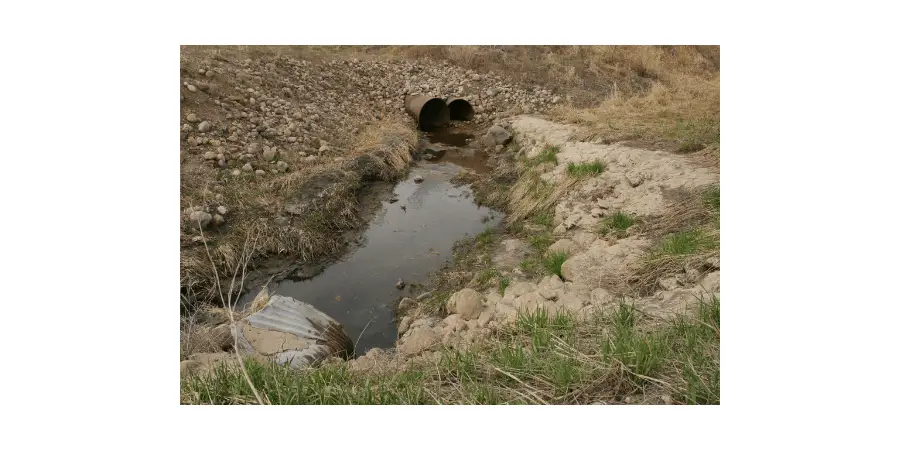 rusted, crushed metal culvert in use