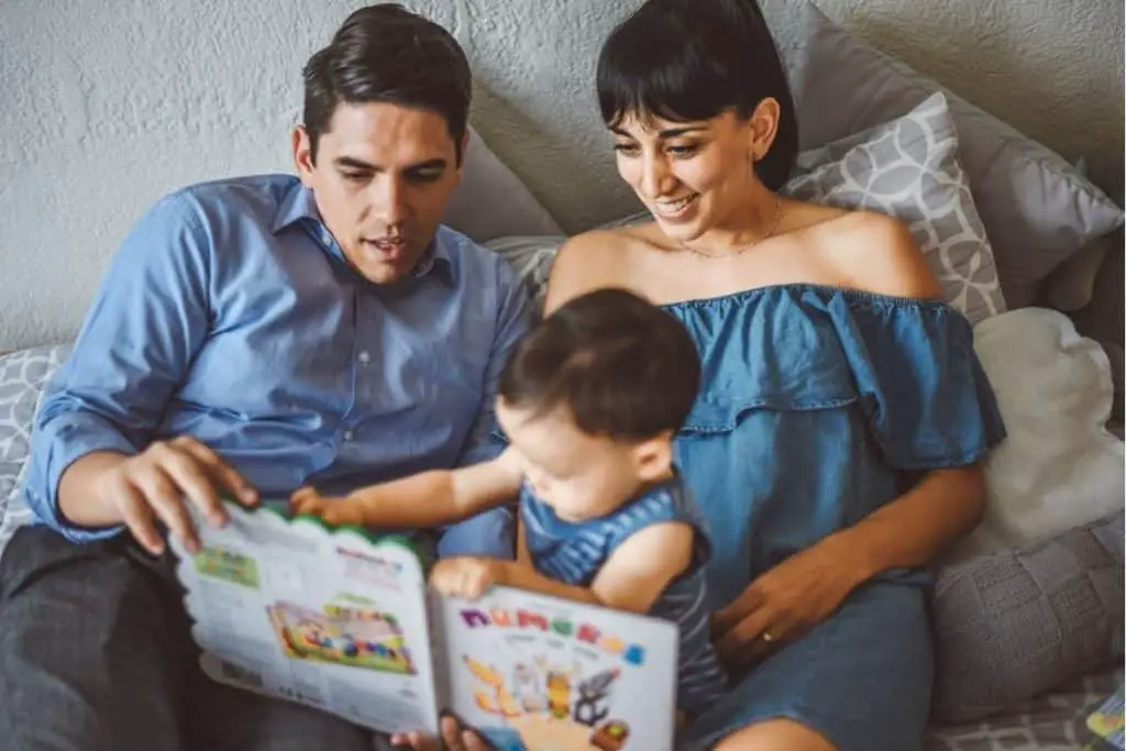 dad, mom & infant going through a picture book together in a small space