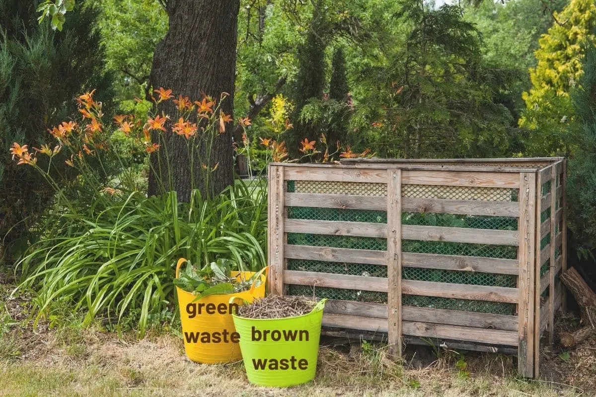neatly built compost bin with examples of green and brown waste